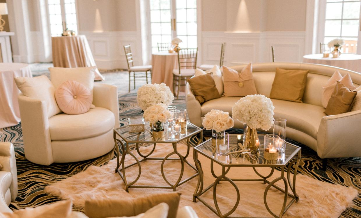 the azalea ballroom decorated for a wedding, with glass tables white couches and flowers as decorations