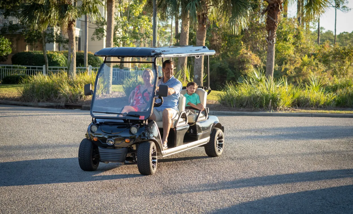 family riding in a golf cart