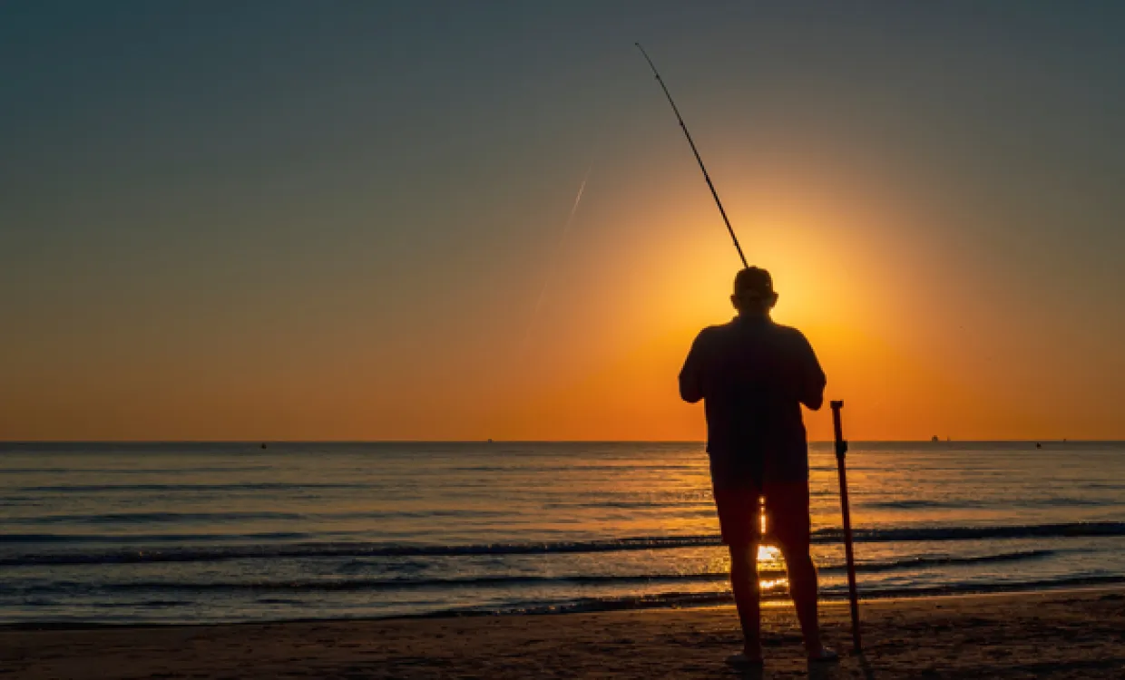 Man Fishing on the Beach at Sunset
