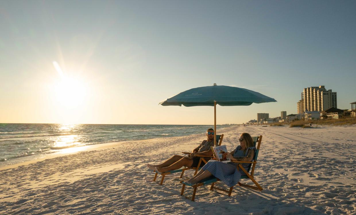Couple enjoying the beach at sunset at the Beach Club Sandstin